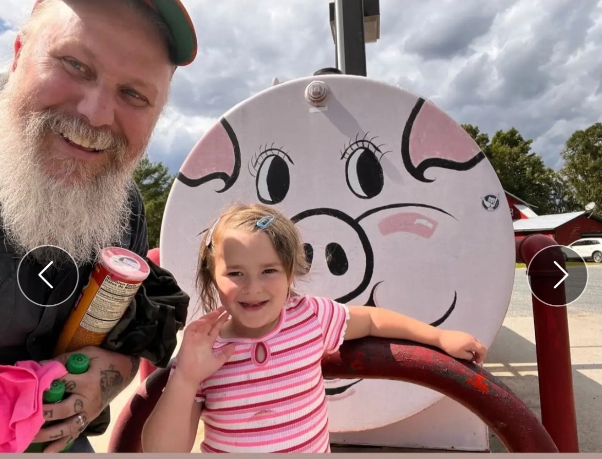 Dad and daughter posing with the famous pig gas pump